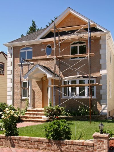 New-Home-Construction-min A residential house with scaffolding in front, indicating ongoing renovation or construction.